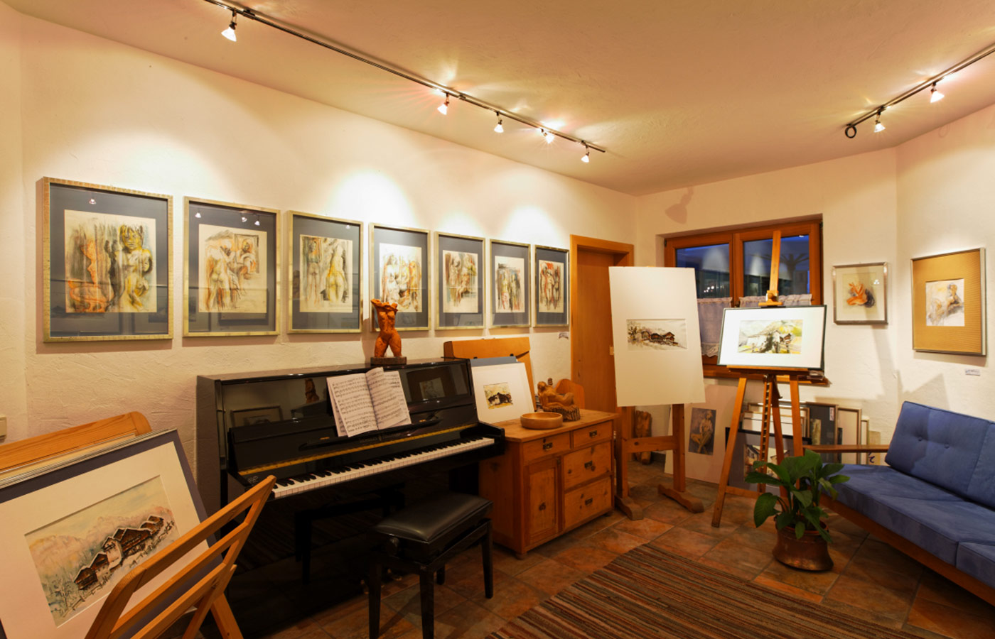 Gemälde und ein Klavier im Atelier des Garnì Raetia