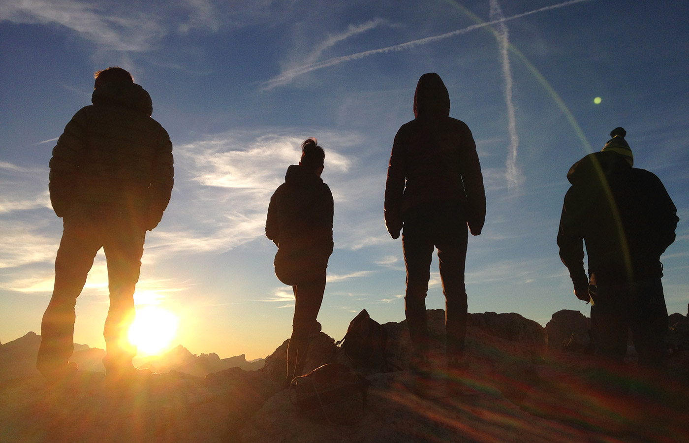 Group of hikers on a mountain peak at dawn