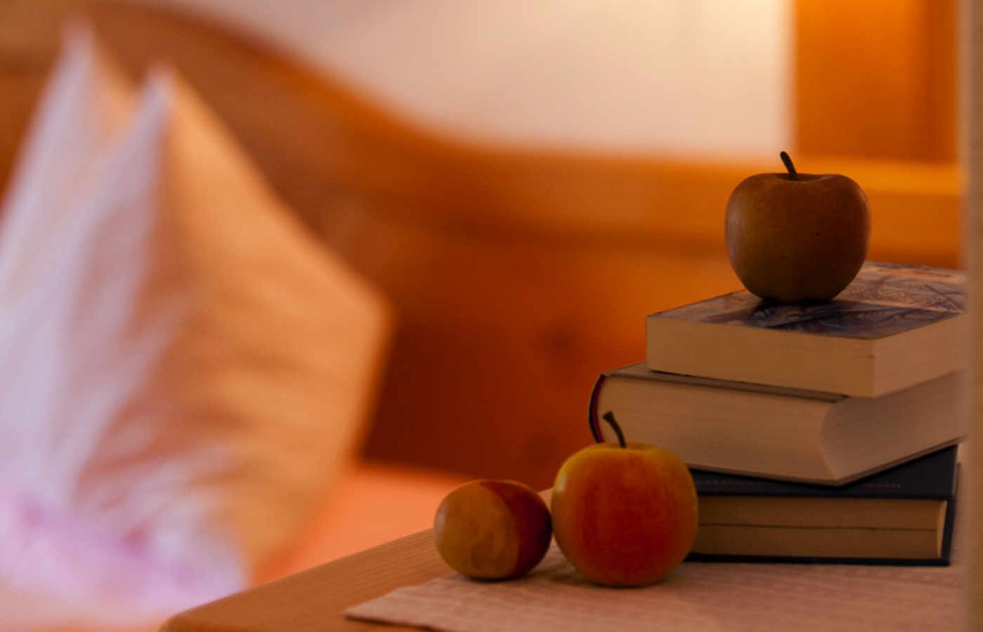 Detail eines Zimmers im Garnì Raetia mit Büchern und Äpfeln auf einem Nachttisch